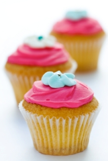 three vanilla cupcakes with pink frosting